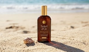 Bouteille d'huile bronzante présentée dans une ambiance estivale et tropicale.